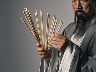 筮竹を使って易占いをする漢服を着た男性