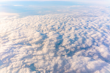 Beautiful orange and pink sunrise over the clouds, view from the plane.