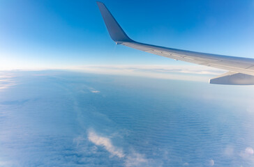 Obraz premium View from the airplane window at a beautiful cloudy sky and the airplane wing
