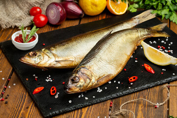 Fish. Smoked whitefish. Smoked fish on the table with toppings. Vegetables and fish. 