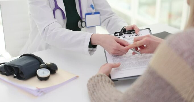 Doctor gives medical consent form to patient at clinic office