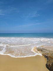 The beach is quiet but there is the sound of waves.