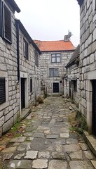 Fototapeta premium Charming European Street with Historic Stone Houses, Narrow Pathway, and Traditional Shutters