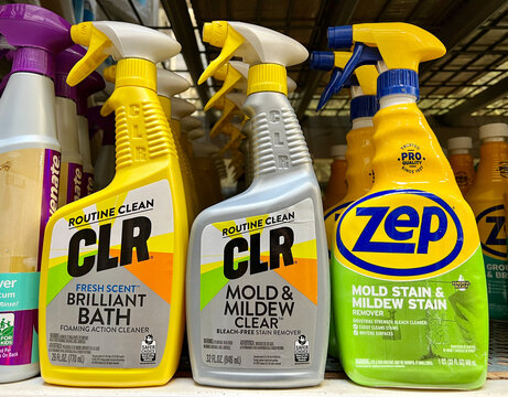 Spray bottles of CLR and ZEP brands of cleaners on a shelf.