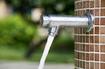 Shower on the beach. Closeup of outdoor shower head. Outdoor pool shower. Water running from poolside shower sprinkler