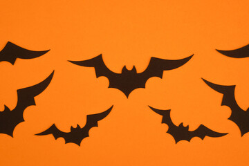 Black bats flying against an orange background during Halloween decoration preparation
