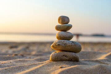 Zen stones background. Pyramid of stones on the background of sunset on the sea beach. Relax, balance, calm, concept.