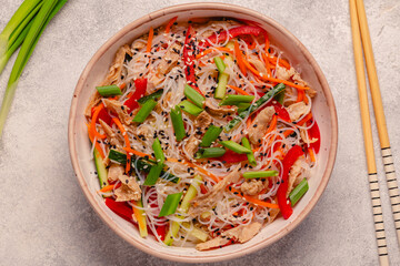 Bowl of rice noodles with vegan soy meat and vegetables.
