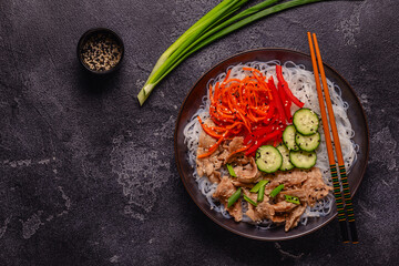 Bowl of rice noodles with vegan soy meat and vegetables.