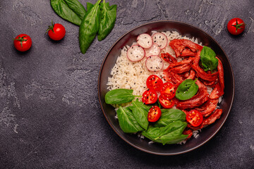Bowl with vegan fried soy meat and vegetables served with boiled rice.