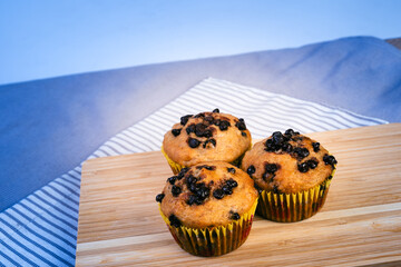 Banana chocolate chip muffins on wooden board. Breakfast or snack recipe idea.