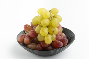 Delicious grapes on a black plate.