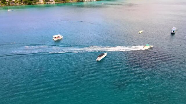 Motorboat Cruises Across Shoreline Pier in Vibrant Emerald Waters
