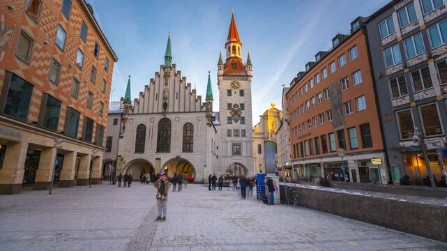 Munich Marienplatz with the old Munich town hall (Altes Rathaus) and the Talburg Gate timelapse, Tower with clock and spire. Cloudy sky. Munchen-Altstadt, Bavaria, Germany.