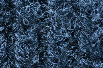 macro texture of woolen dark gray fluffy sweater, warm crocheted fabric as background, close up of gray crocheted front surface, texture of woolen wool, crocheted front surface