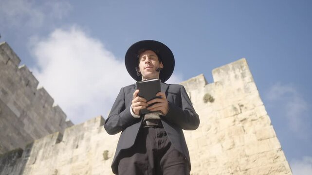 Orthodox Jewish man praying holding Torah Hebrew Bible in Jerusalem, Israel