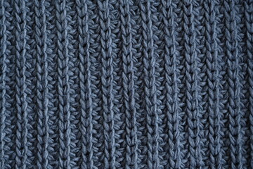 macro texture of woolen dark gray crocheted sweater as background, close-up of gray crocheted front surface, woolen texture of woolen wool, knitted front surface