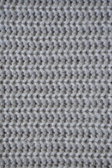 macro texture of woolen pastel crocheted sweater as background, close-up of brown crocheted front surface, woolen texture of woolen wool, trend pastel crocheted front surface