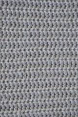 macro texture of woolen pastel crocheted sweater as background, close-up of brown crocheted front surface, woolen texture of woolen wool, trend pastel crocheted front surface