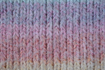 Fototapeta premium Macro texture of acrylic multicolored crocheted sweater as background, close up of rainbow front surface, multicolored crocheted wool texture, crocheted front surface