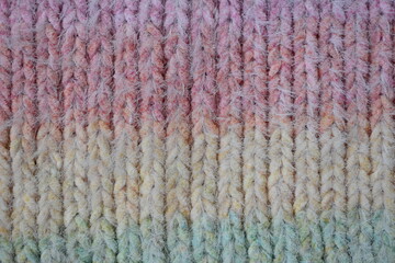 Macro texture of acrylic multicolored crocheted sweater as background, close up of rainbow front surface, multicolored crocheted wool texture, crocheted front surface