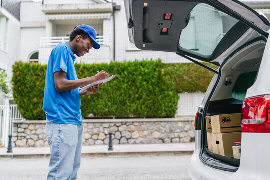 Delivery man organizing a package in the car while preparing for deliveries.