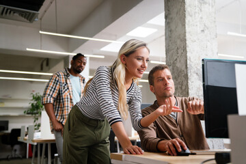 Group of young multi-ethnic startup business team collaborating on project in modern office