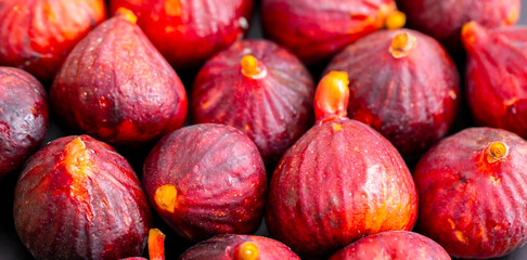 Figs close-up. Heap of figs, whole fruits and cut in half. Sweet exotic fruit for dessert, healthy food.