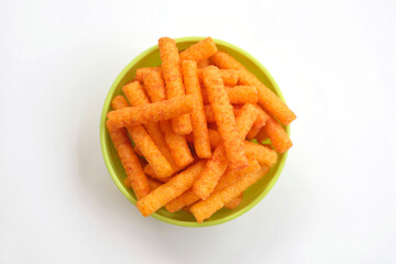 Snack stick spicy crunchy corn balado flavor in a green bowl isolated on white background
