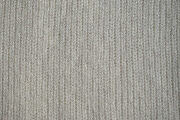 macro texture of woolen white crocheted sweater as background, close-up of blue crocheted front surface, woolen texture of woolen wool, crocheted front surface