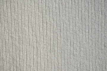 macro texture of woolen white crocheted sweater as background, close-up of blue crocheted front surface, woolen texture of woolen wool, crocheted front surface