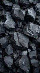 Black Coal Pieces Stacked in a Close-Up View, Showcasing Their Rough Texture and Varying Shapes Under Natural Lighting