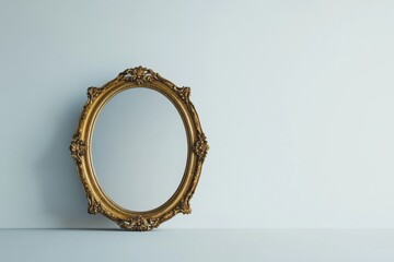 Obraz premium Elegant vintage mirror with ornate gold detailing displayed against a simple backdrop in a stylish interior setting