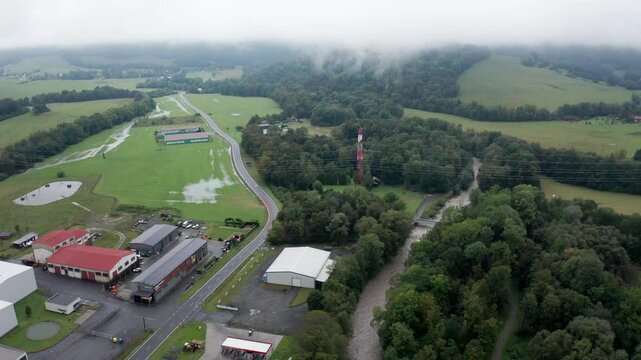 Drone shot of overflowing river with road and mist