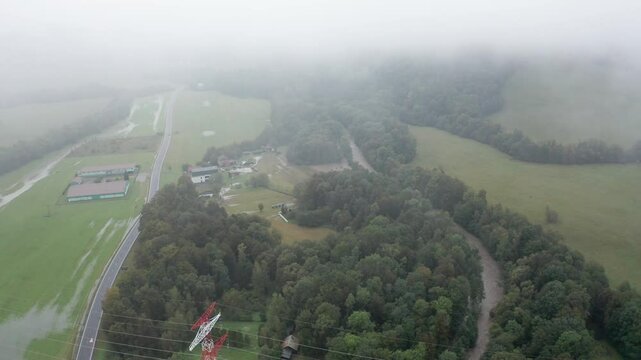Drone shot of overflowing river with road and mist
