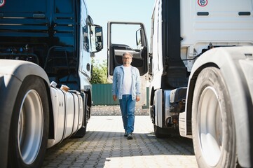 Happy confident male driver standing in front on his truck