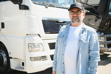 Happy confident male driver standing in front on his truck