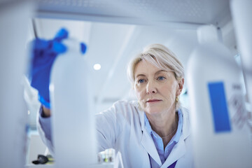 Mature scientist, product and medical research in science lab for chemistry experiment in healthcare. Female person, storage and chemical for pharmaceutical test, analysis or mpox vaccine in hospital