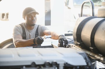 Repairing Broken Semi Truck Tractor Engine. African american Trucks Mechanic