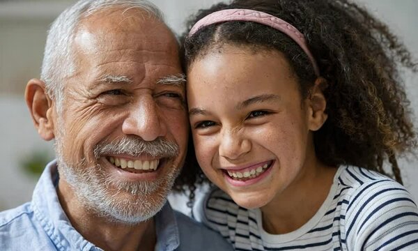 Grandparent Bond: A mid-shot of a grandfather with his granddaughter, both smiling brightly, showing a powerful intergenerational connection.