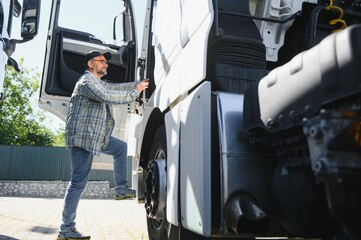 Truck driver climbing into cab of semi-truck