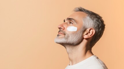 Man applying facial cream at home with a calm expression against a warm background in the afternoon light