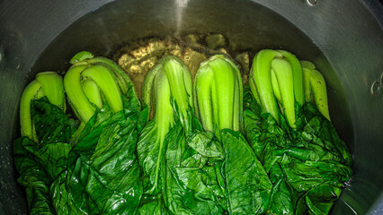 Pakcoy boiled in a cauldron filled with hot water