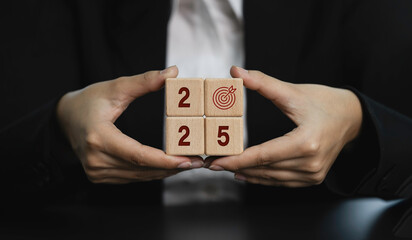 Businesswoman holding wooden blocks with business target symbol. 2025 Business Growth. Financial...