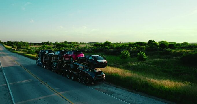 Stinger trailer with double deck car parked on country road at the sunset.