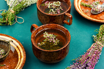Medicinal tea in cup with herb.