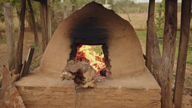 Close up of tatakua, a traditional handmade clay oven from Paraguay, with wood flames heating the oven to later bake typical foods
