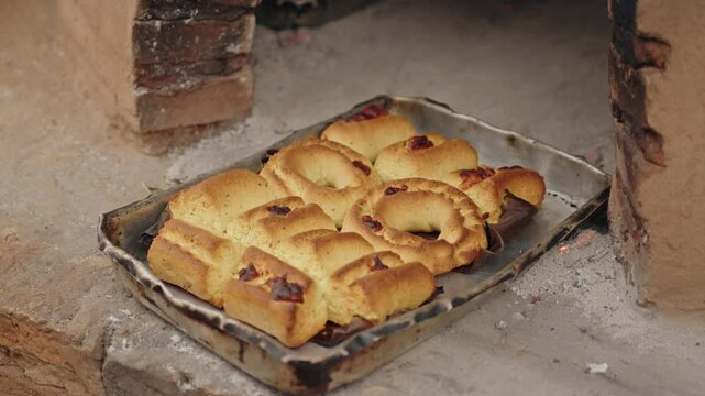 Freshly baked Paraguayan chipa coming out of the tatakua, a traditional Paraguayan clay oven