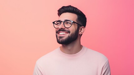 Fototapeta premium Smiling young man with beard and glasses on a pink background during a cheerful moment