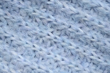 macro texture of woolen blue crocheted sweater as background, close-up of blue crocheted front surface, woolen texture of woolen wool, knitted front surface
